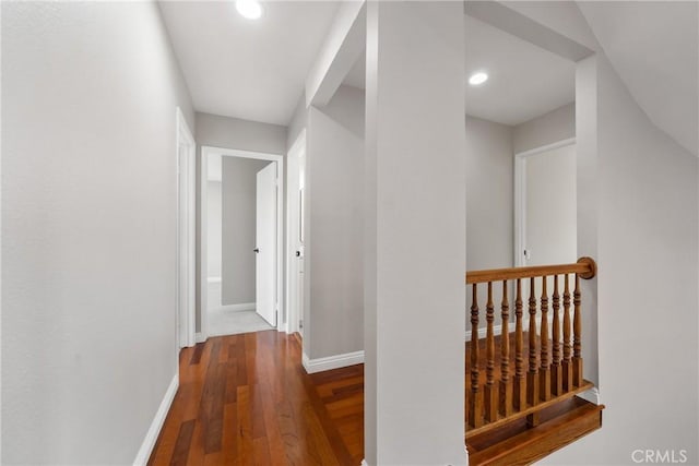 hallway featuring recessed lighting, wood-type flooring, and baseboards