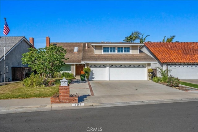 view of front of house featuring a garage, driveway, and a front yard