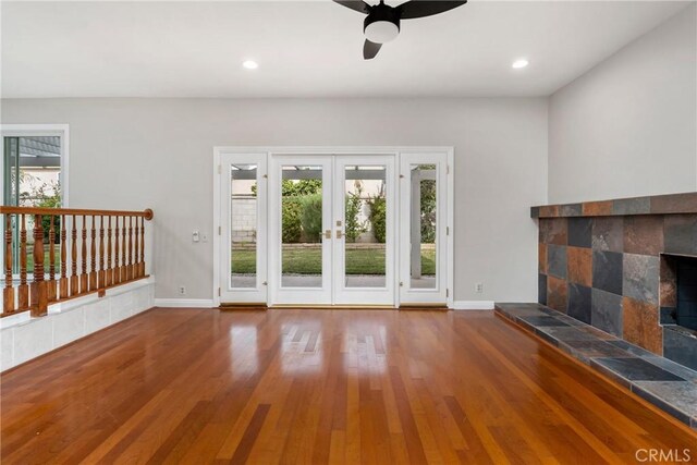 unfurnished living room with ceiling fan, hardwood / wood-style floors, french doors, and a healthy amount of sunlight