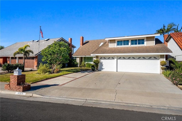 view of front facade featuring concrete driveway, a front lawn, and an attached garage