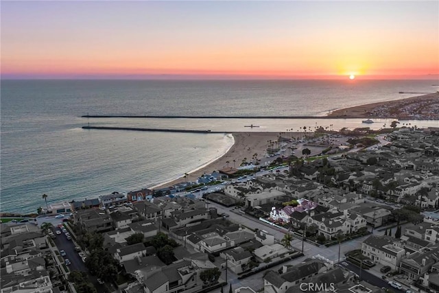 aerial view at dusk featuring a water view