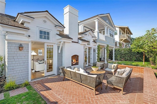 view of patio with an outdoor living space with a fireplace