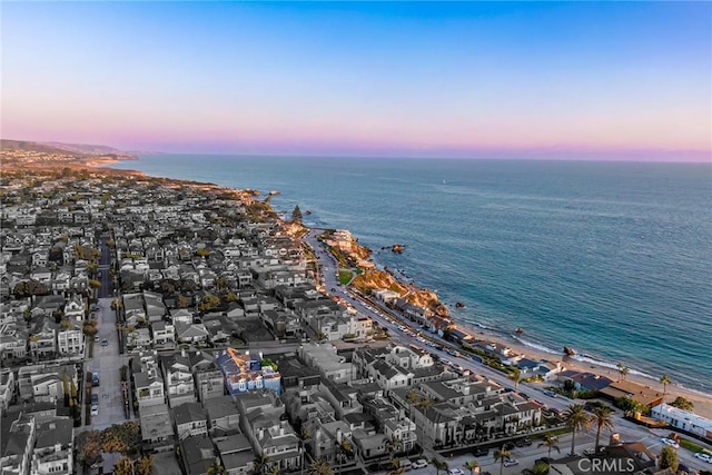 aerial view at dusk featuring a water view