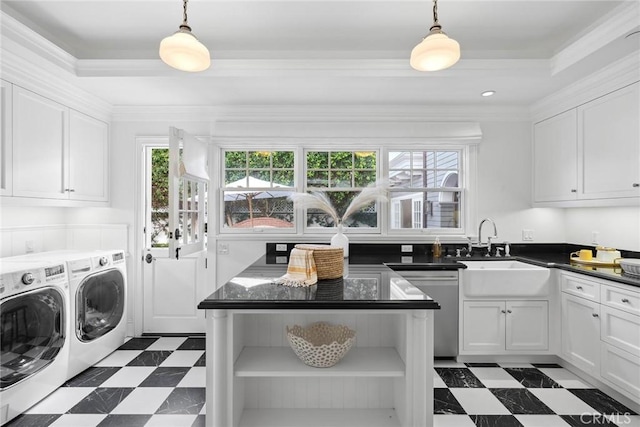 laundry area featuring sink, ornamental molding, washing machine and clothes dryer, and cabinets