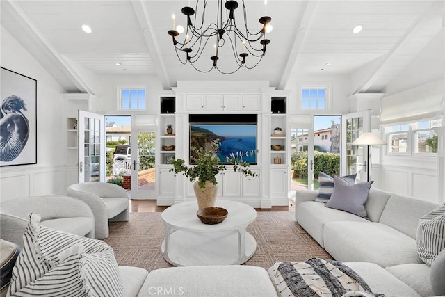 living room with french doors, a wealth of natural light, wood-type flooring, and beamed ceiling