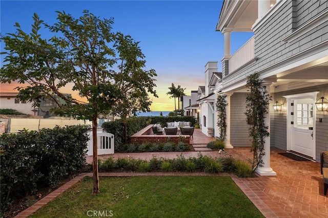 yard at dusk with a patio area and outdoor lounge area