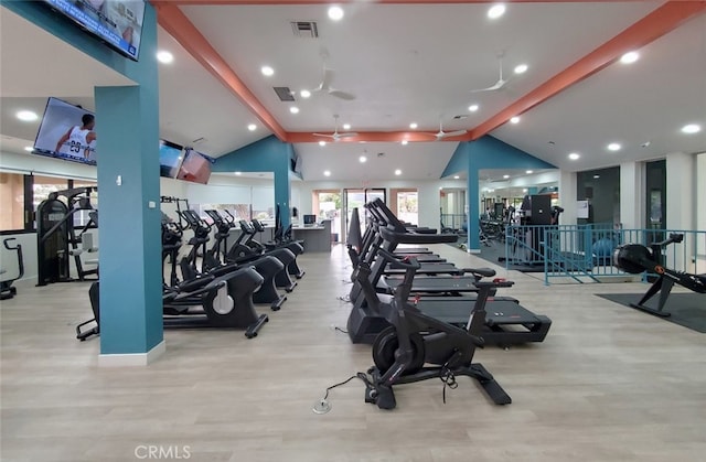 gym featuring lofted ceiling, ceiling fan, and light hardwood / wood-style flooring