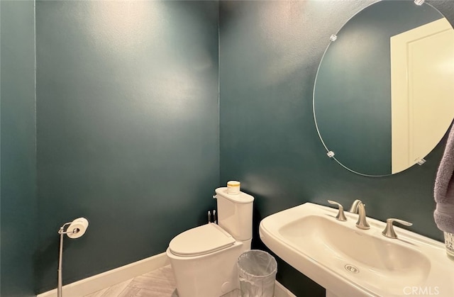 bathroom featuring toilet, tile patterned floors, and sink