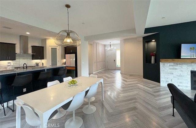 dining space featuring light parquet floors, a chandelier, and a fireplace