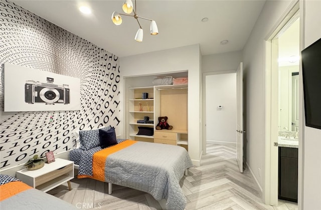 bedroom featuring an inviting chandelier and light parquet floors