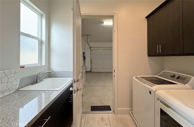 washroom featuring cabinets, sink, washing machine and dryer, and light tile patterned flooring