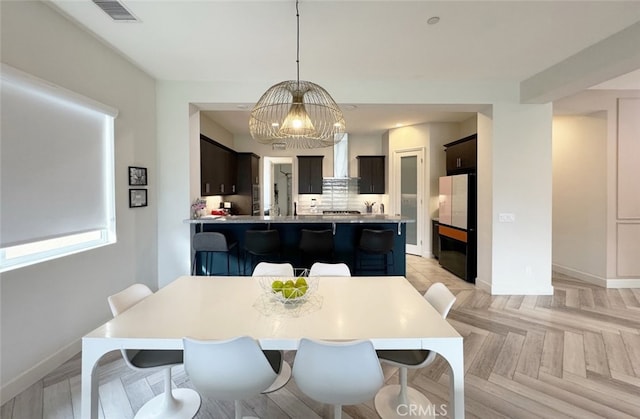 dining area featuring an inviting chandelier and light parquet flooring