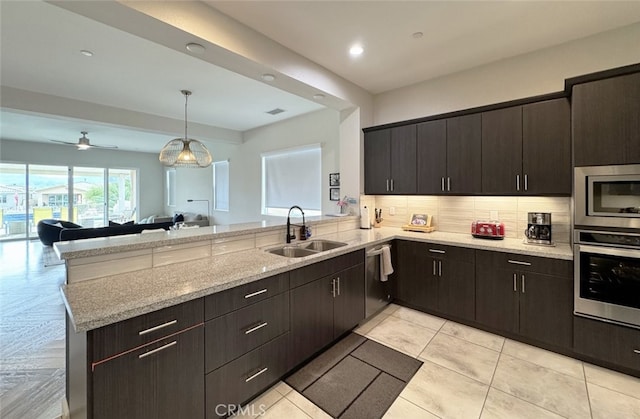 kitchen featuring ceiling fan, kitchen peninsula, sink, dark brown cabinetry, and stainless steel appliances