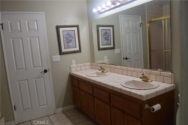 bathroom featuring a shower with shower door, vanity, and tile patterned flooring