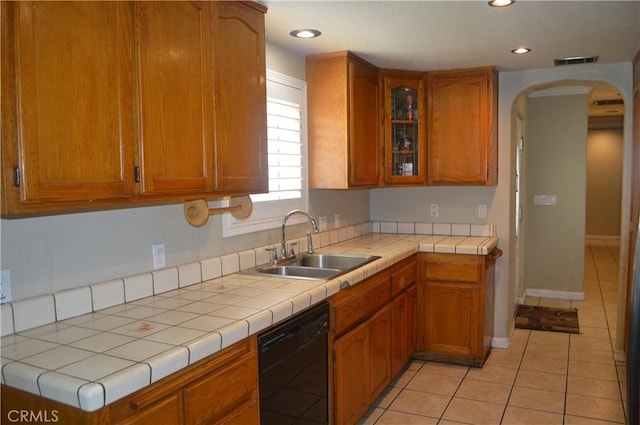 kitchen with tile counters, dishwasher, sink, and light tile patterned flooring