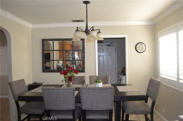 dining space featuring a notable chandelier, tile patterned floors, and crown molding