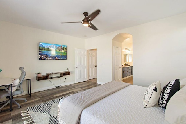 bedroom featuring ceiling fan, ensuite bath, and hardwood / wood-style floors