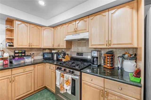 kitchen with tasteful backsplash, light brown cabinets, dark tile patterned flooring, and stainless steel gas range