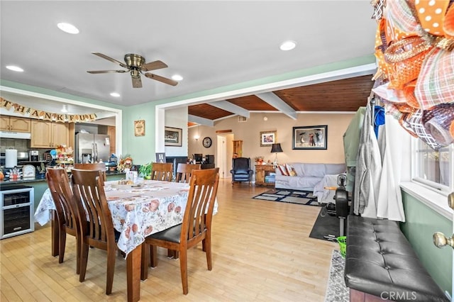 dining area featuring vaulted ceiling with beams, ceiling fan, light hardwood / wood-style floors, and wine cooler