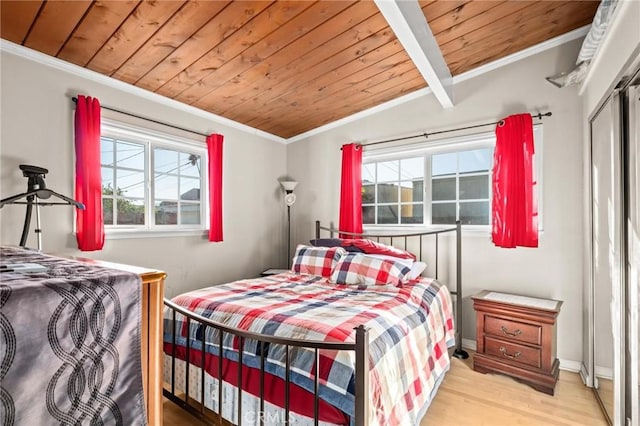 bedroom featuring beam ceiling, light wood-type flooring, wooden ceiling, and multiple windows