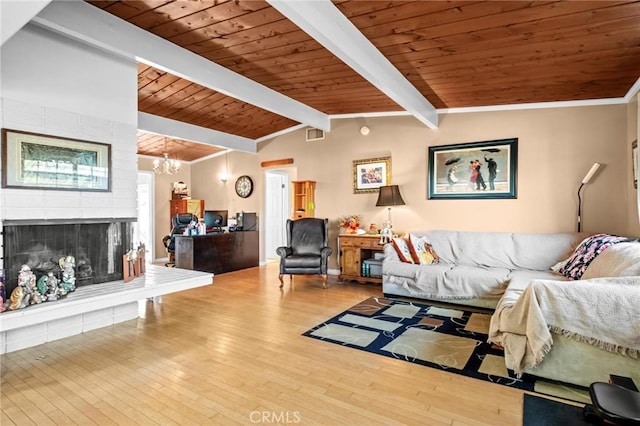 living room with vaulted ceiling with beams, a fireplace, and hardwood / wood-style floors