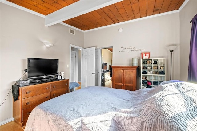 bedroom featuring hardwood / wood-style floors, wooden ceiling, ornamental molding, and beam ceiling