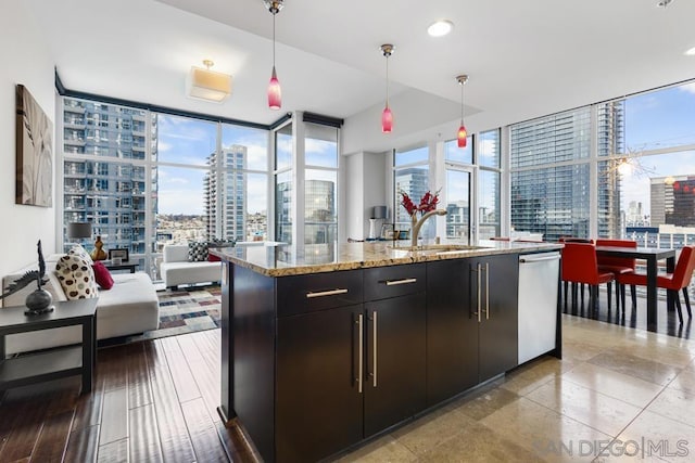 kitchen featuring decorative light fixtures, stainless steel dishwasher, and floor to ceiling windows