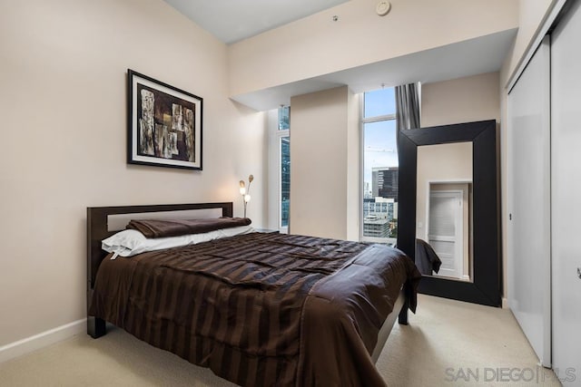 bedroom featuring light colored carpet and a closet