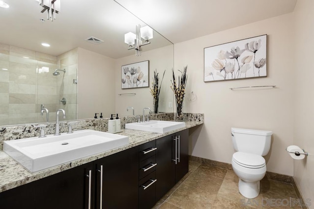 bathroom featuring toilet, a chandelier, a shower with shower door, and vanity