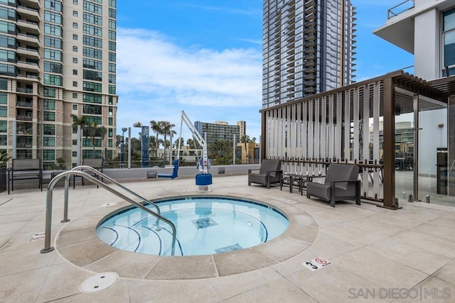 view of swimming pool featuring a community hot tub and a patio