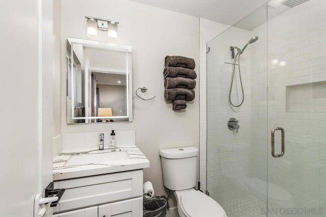 bathroom with vanity, an enclosed shower, and toilet