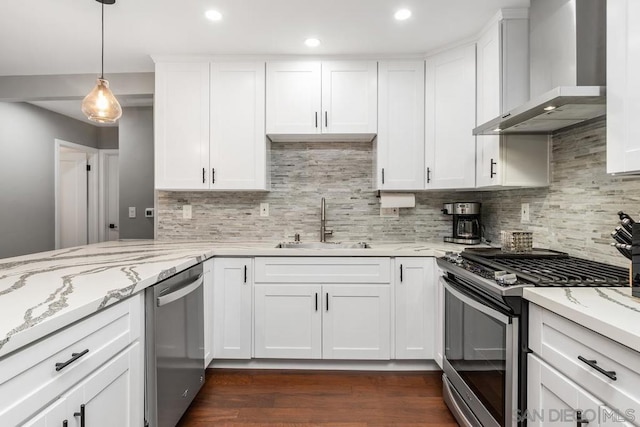 kitchen with white cabinets, backsplash, stainless steel appliances, and wall chimney exhaust hood