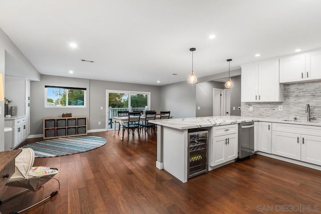 kitchen with white cabinets, sink, wine cooler, and kitchen peninsula