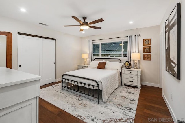 bedroom featuring dark hardwood / wood-style flooring, ceiling fan, and a closet