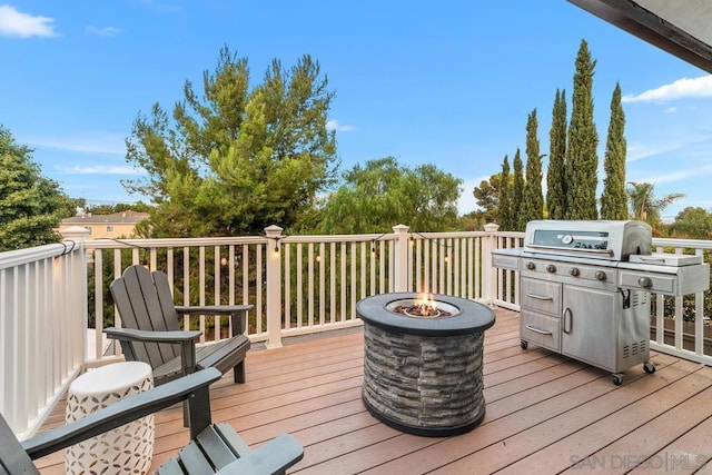 wooden terrace featuring an outdoor fire pit