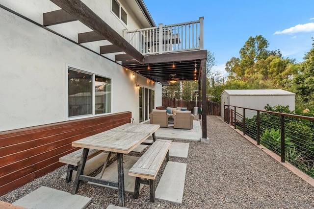 view of patio featuring a balcony, an outdoor living space, and a storage unit