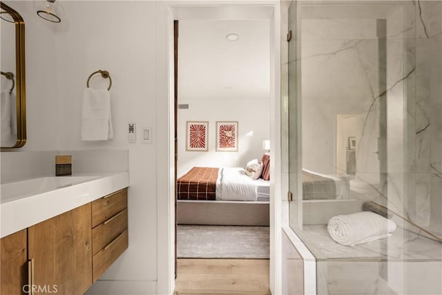 bathroom with vanity, a shower with door, and hardwood / wood-style floors