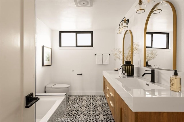 bathroom featuring tile patterned floors, toilet, vanity, and a bathing tub