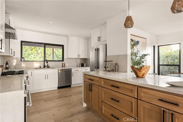 kitchen with premium appliances, white cabinets, and light stone counters