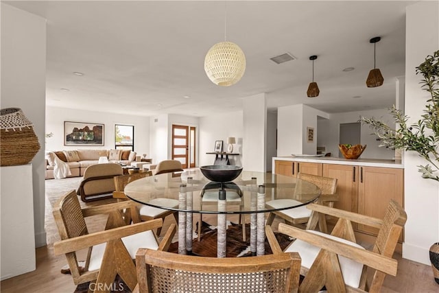 dining room featuring light wood-type flooring and a chandelier