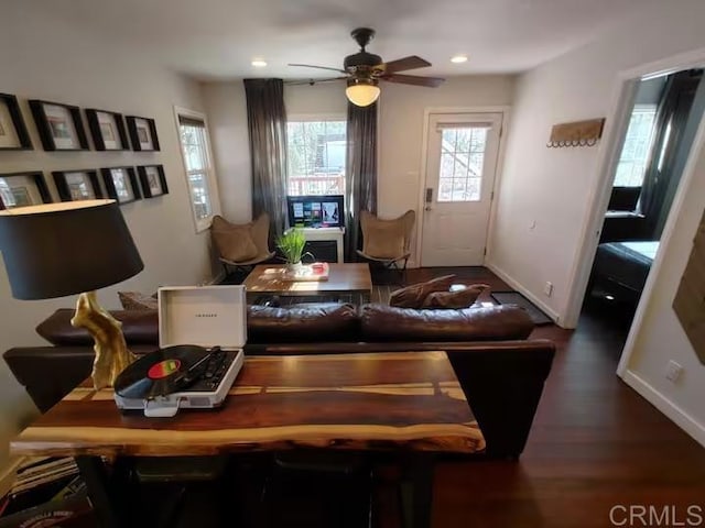 living room with ceiling fan and dark hardwood / wood-style flooring