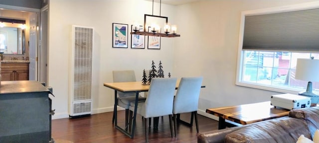 dining room with dark wood-type flooring and an inviting chandelier