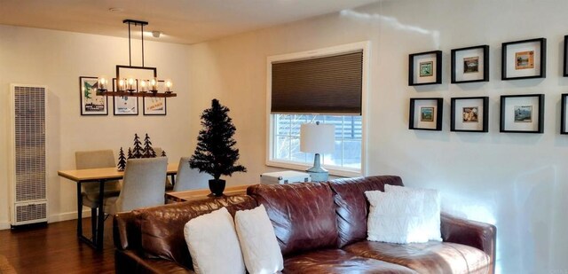 living room featuring an inviting chandelier and dark hardwood / wood-style flooring