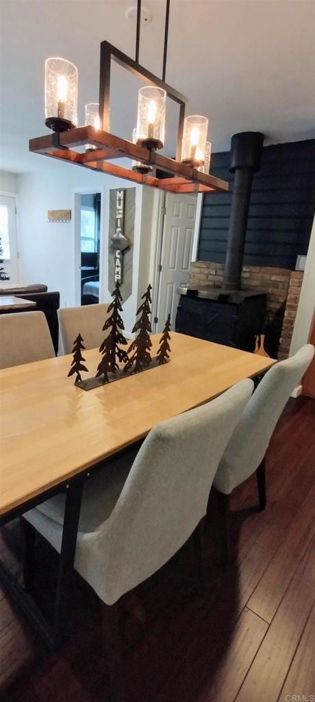 dining space with a wood stove and hardwood / wood-style floors