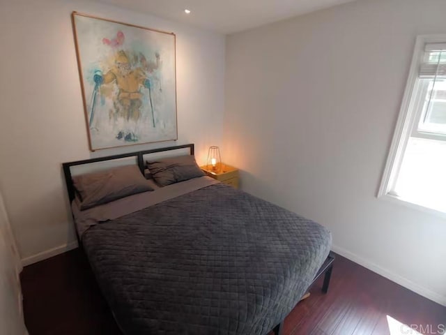 bedroom featuring dark hardwood / wood-style flooring and multiple windows