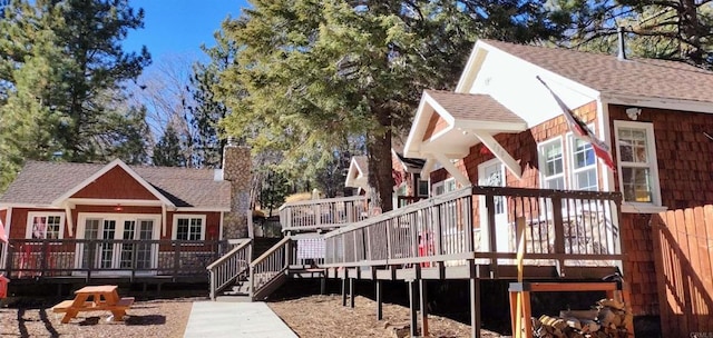 rear view of property with a deck and french doors