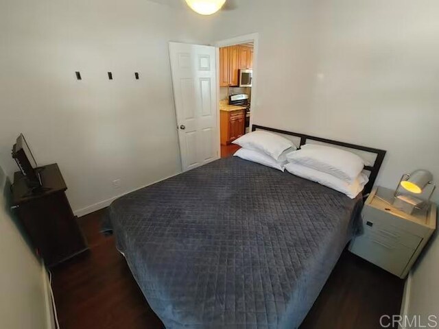 bedroom with dark wood-type flooring