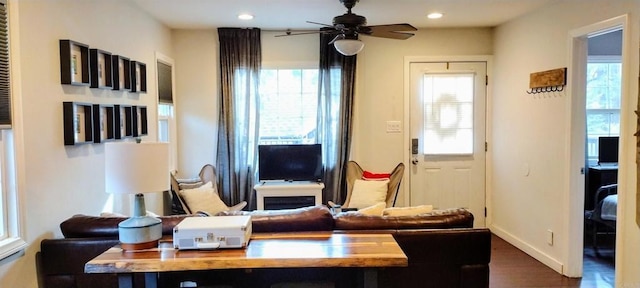 living room featuring ceiling fan and dark hardwood / wood-style floors