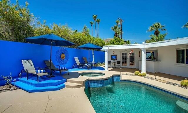 view of swimming pool with french doors, a patio, and an in ground hot tub