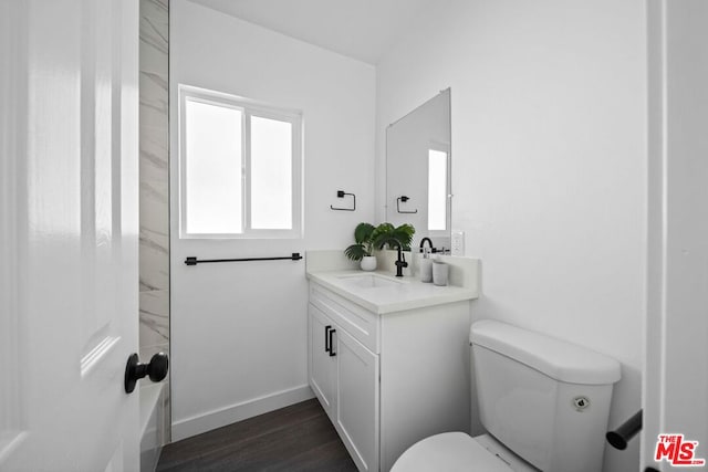 bathroom with toilet, wood-type flooring, and vanity